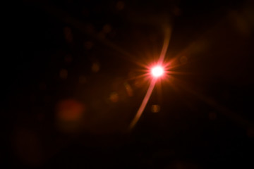 abstract lens flare red light over black background