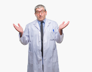 Handsome senior doctor, scientist professional man wearing white coat over isolated background clueless and confused expression with arms and hands raised. Doubt concept.