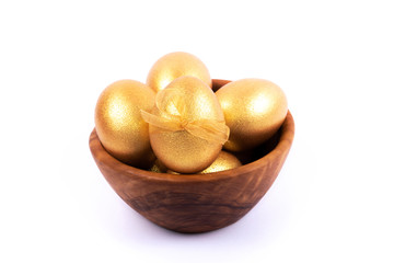 Golden and silver colored Easter eggs in wooden bowl isolated on white background. Place for text.
