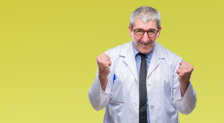 Handsome senior doctor, scientist professional man wearing white coat over isolated background very happy and excited doing winner gesture with arms raised, smiling and screaming for success