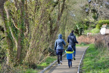 Une famille qui marche sur un plancher de bois dans les zones humides à Trestel en Bretagne