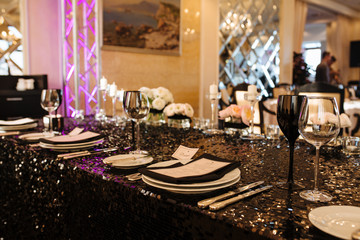 Wedding decor. Reception. Table number 1 on black wooden stand. Glasses and cutlery on side. Steampunk style