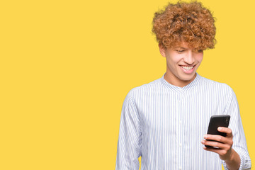 Fototapeta premium Young handsome man using smartphone with a happy face standing and smiling with a confident smile showing teeth