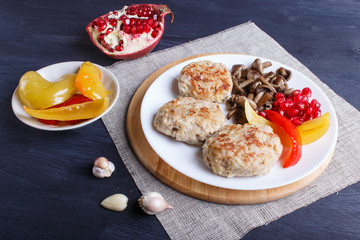 meatballs with rice mushrooms, sweet peppers and pomegranate seeds on black wooden background.