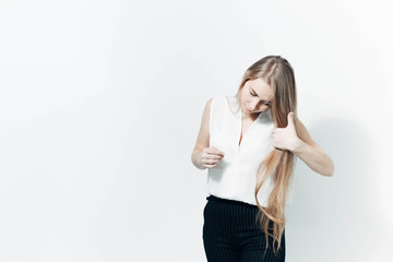 portrait of a beautiful long-haired blonde girl with blue eyes in business clothes in a white studio.