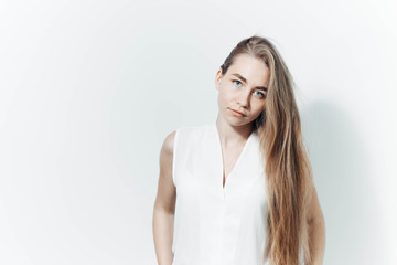 Obraz premium portrait of a beautiful long-haired blonde girl with blue eyes in business clothes in a white studio.