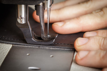 stitching leather products in a leather workshop