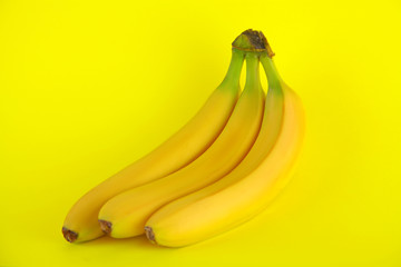 Three bananas in bunches on a bright background. Copy space