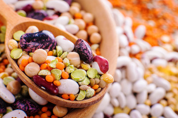 composition of dry legumes of different types, color and flavor on rustic wood background