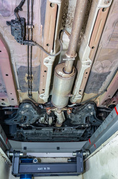 chassis, suspension, particulate filter and exhaust of a car seen from the inspection pit