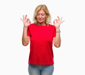 Middle age blonde woman over isolated background relax and smiling with eyes closed doing meditation gesture with fingers. Yoga concept.