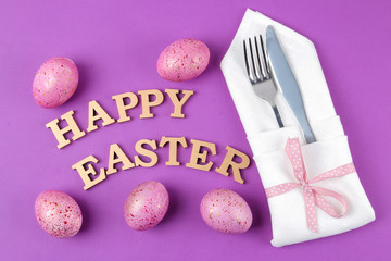 Easter. Pink easter eggs and knife with fork. Easter table setting. on trendy purple background. Happy easter. holidays. top view