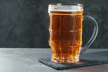 Single beer glass close up on dark stone background