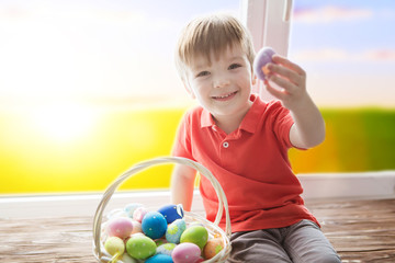 happy boy with festive easter eggs in the park
