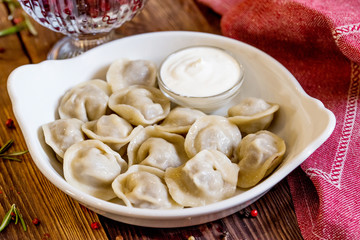 Dumplings with sour cream in a white plate