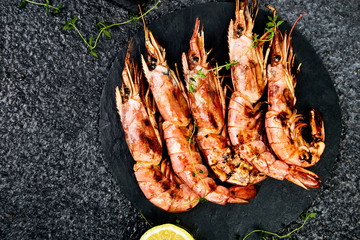 Grilled big tiger shrimps prawns on black slate plate