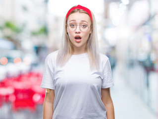 Young blonde woman wearing glasses over isolated background afraid and shocked with surprise expression, fear and excited face.