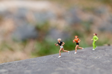 Miniature people Running on The Rock