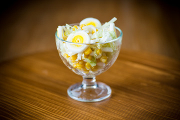 Fresh Peking cabbage salad with boiled eggs, canned corn