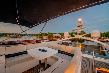  A premium class yacht stands by the wharf in everlasting sunshine in the summer. Sunset
