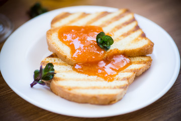Obraz na płótnie Canvas fried toast with apricot jam in a plate