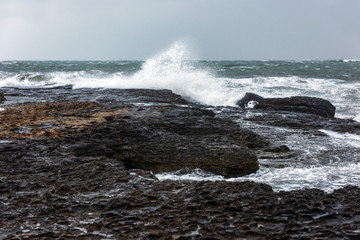 Splash of huge waves on a rocky shore