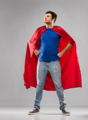 super power and people concept - happy young man in red superhero cape over grey background
