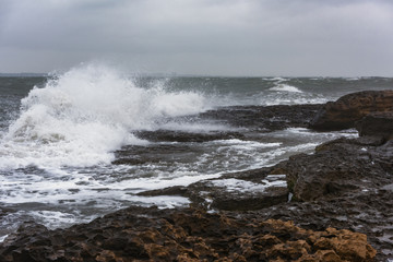 Splash of huge waves on a rocky shore