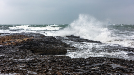 Fototapeta premium Splash of huge waves on a rocky shore
