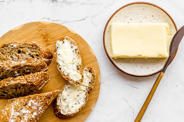 Slice of bread with butter on white background top view
