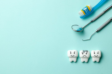 Healthy white teeth are smiling and tooth with caries is sad on green mint background. Toothbrush...