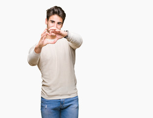 Young handsome man over isolated background smiling in love showing heart symbol and shape with hands. Romantic concept.