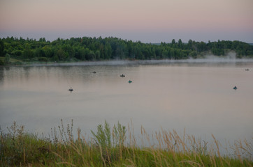 Obraz na płótnie Canvas fishermen early in the morning fishing on the lake