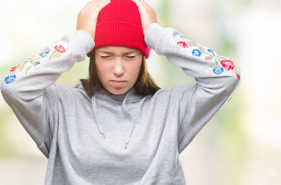 Young caucasian beautiful woman wearing wool cap over isolated background suffering from headache desperate and stressed because pain and migraine. Hands on head.