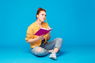 education, high school, inspiration and people concept - red haired teenage girl in checkered shirt...
