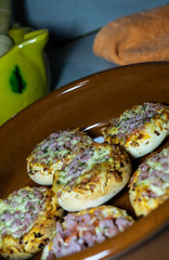 SMALL PIZZAS IN A ROLLED PLATE IN A KITCHEN TABLE