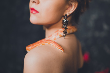 Red python envelops the neck of the girl.