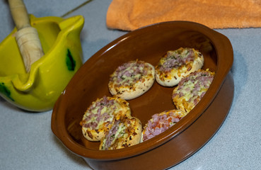 SMALL PIZZAS IN A ROLLED PLATE IN A KITCHEN TABLE