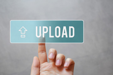 Upload - hand pressing transparent blue button with arrow on virtual touchscreen interface  grey background with copy space for text. Internet application files uploading sharing  concept.