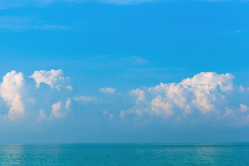 Obraz premium Beautiful morning white and pink clouds on a blue sky over the sea.Copy space in the sky above the clouds. Sunrise and sunset .Concept of decoration, travel, vacation,relaxation.