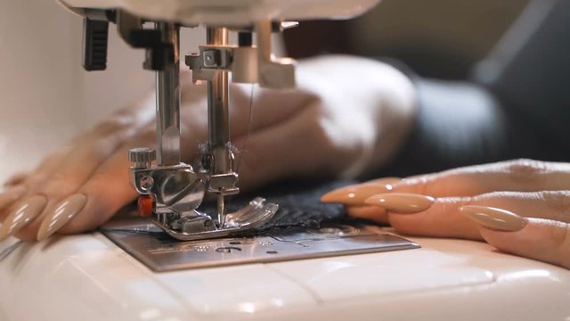 Tailor sews lingerie on a sewing machine