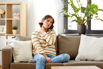 Obraz premium people, healthcare and problem concept - unhappy woman suffering from neck pain at home