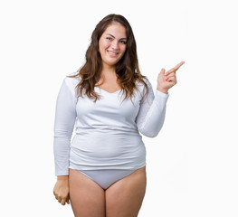 Beautiful plus size young overwight woman wearing white underwear over isolated background with a big smile on face, pointing with hand and finger to the side looking at the camera.