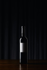 Fototapeta na wymiar Wine bottle with blank label on wooden surface