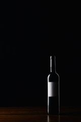 Wine bottle with blank label on wooden surface
