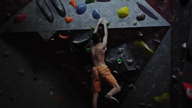 Athletic man practicing in a bouldering gym