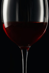 Glass of burgundy red wine isolated on black