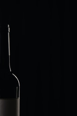 Glass wine bottle with blank label isolated on black
