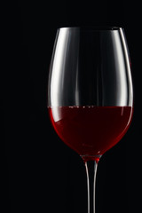 Glass with burgundy red wine isolated on black