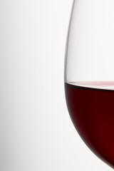 Wine glass of burgundy red wine on white